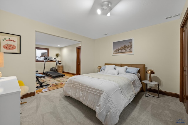 carpeted bedroom with visible vents and baseboards