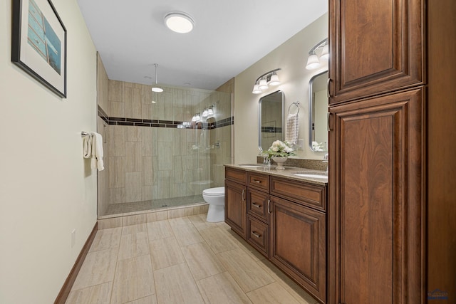 full bath with toilet, a sink, baseboards, double vanity, and walk in shower