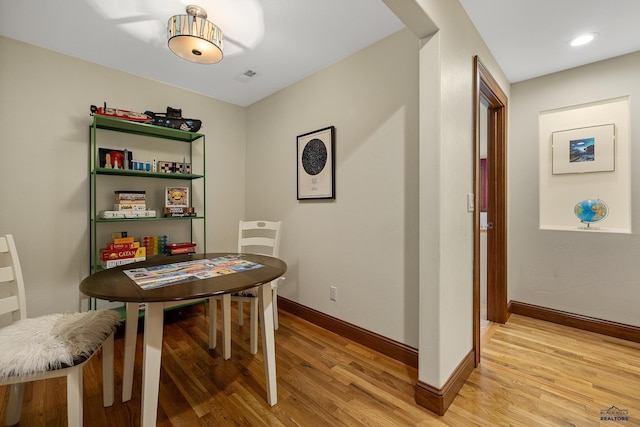 dining room with baseboards, visible vents, and light wood finished floors