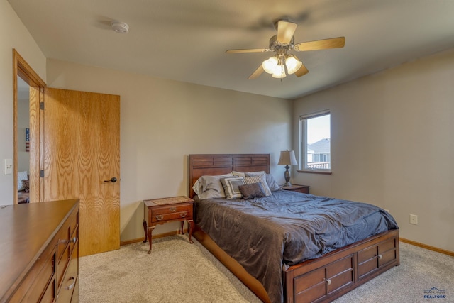 bedroom featuring light carpet, a ceiling fan, and baseboards