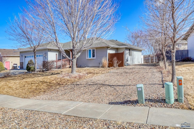 ranch-style home featuring a garage and fence