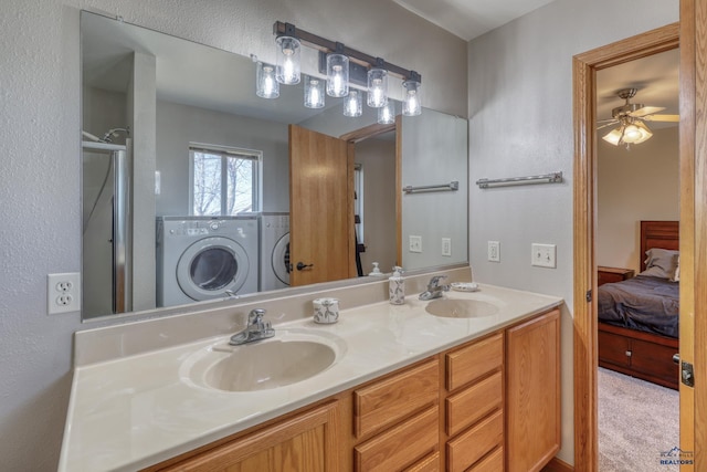 ensuite bathroom with double vanity, ensuite bathroom, a sink, and washing machine and clothes dryer