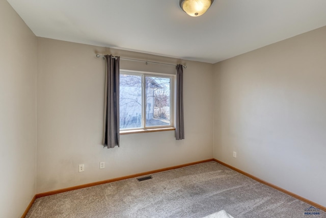 carpeted empty room featuring visible vents and baseboards
