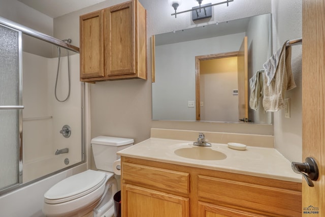 full bath with toilet, bath / shower combo with glass door, and vanity