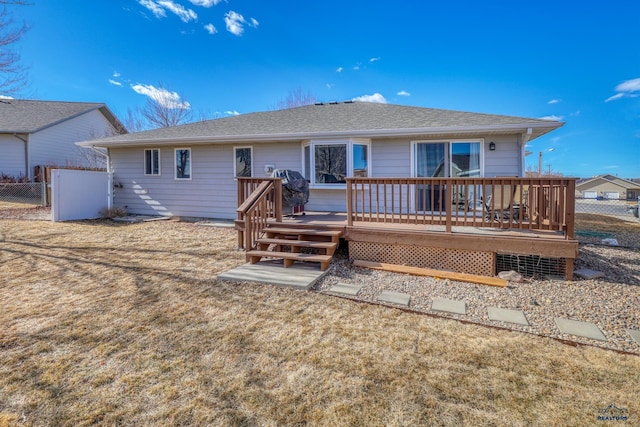 back of house featuring a shingled roof, fence, and a wooden deck