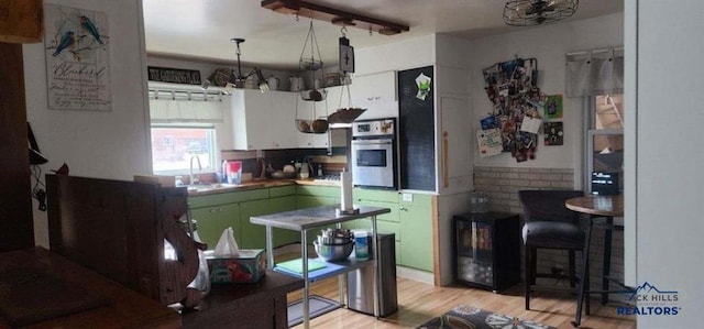 1001 E St, Edgemont, SD 57735 - kitchen with wine cooler, oven, a sink, light wood-type flooring, and green cabinetry