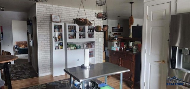 1001 E St, Edgemont, SD 57735 - kitchen with brick wall, stainless steel fridge with ice dispenser, and wood finished floors