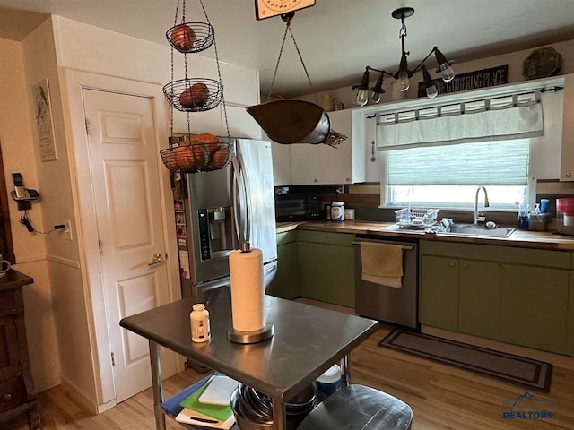 1001 E St, Edgemont, SD 57735 - kitchen with stainless steel appliances, light wood-style floors, green cabinetry, and a sink