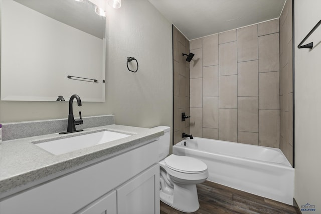 bathroom with toilet, shower / bathtub combination, wood finished floors, and vanity