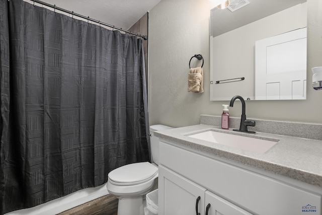 bathroom featuring curtained shower, visible vents, vanity, and toilet