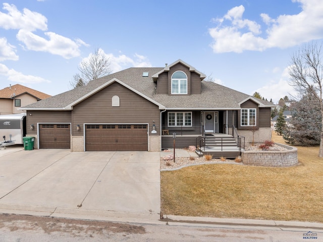 view of front of property featuring a shingled roof, a front yard, concrete driveway, and an attached garage