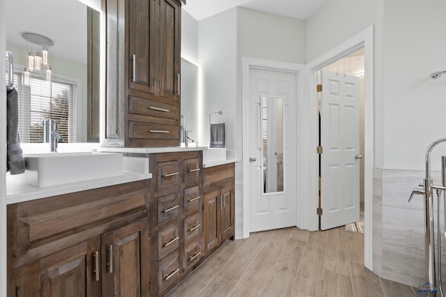 full bathroom featuring double vanity, a sink, and wood finished floors