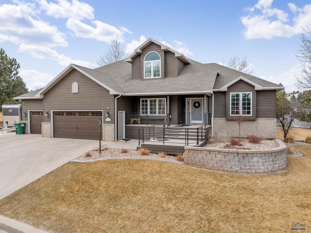 view of front of house featuring a porch, an attached garage, a shingled roof, driveway, and a front yard