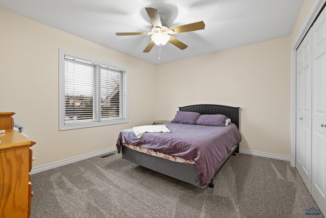 carpeted bedroom featuring ceiling fan, visible vents, baseboards, and a closet