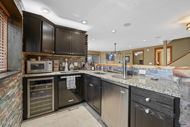 kitchen featuring a peninsula, beverage cooler, a sink, and recessed lighting