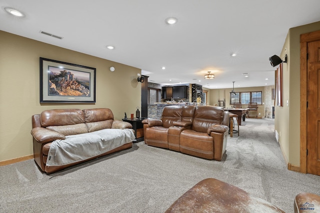 living room with recessed lighting, visible vents, baseboards, and light colored carpet