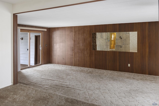 unfurnished room with carpet floors and wood walls