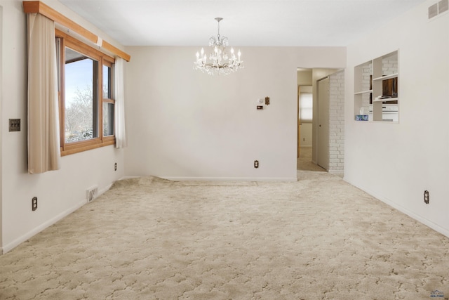 carpeted spare room featuring baseboards, visible vents, and a notable chandelier