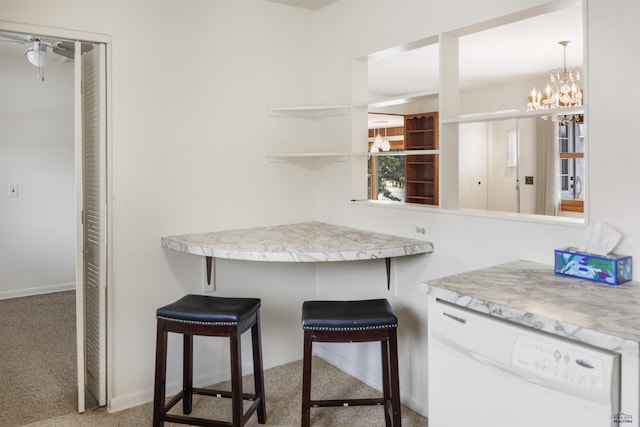 kitchen with carpet floors, white dishwasher, a kitchen breakfast bar, and light countertops