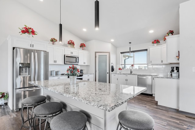 14113 Treasure Coach Rd, Piedmont, SD 57769 - kitchen featuring vaulted ceiling, light stone countertops, a breakfast bar, stainless steel appliances, and white cabinets