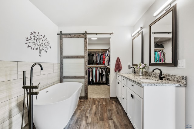 14113 Treasure Coach Rd, Piedmont, SD 57769 - bathroom featuring tile walls, a sink, a freestanding tub, and a walk in closet