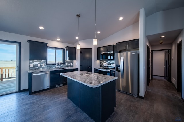 kitchen featuring dark wood-style flooring, stainless steel appliances, lofted ceiling, a sink, and a kitchen island