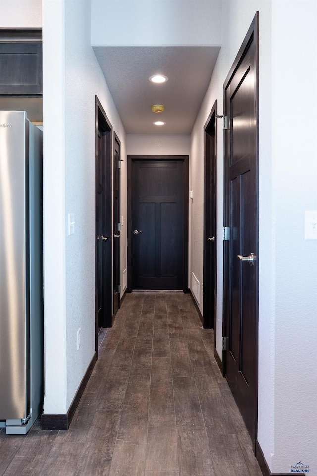 hallway with visible vents and baseboards