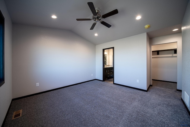 unfurnished bedroom with baseboards, visible vents, lofted ceiling, a spacious closet, and carpet floors