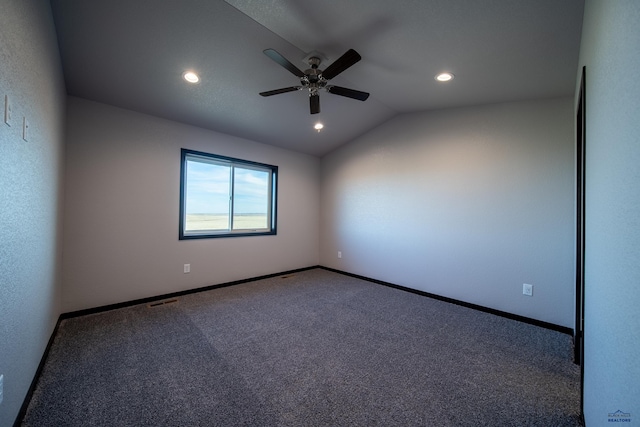 empty room with carpet floors, recessed lighting, vaulted ceiling, and baseboards