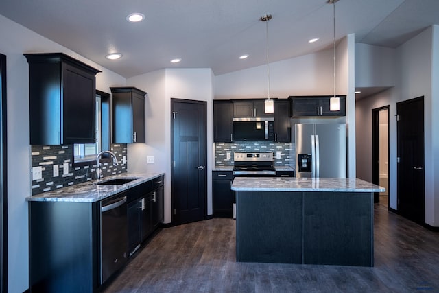 kitchen featuring appliances with stainless steel finishes, a kitchen island, a sink, and light stone countertops