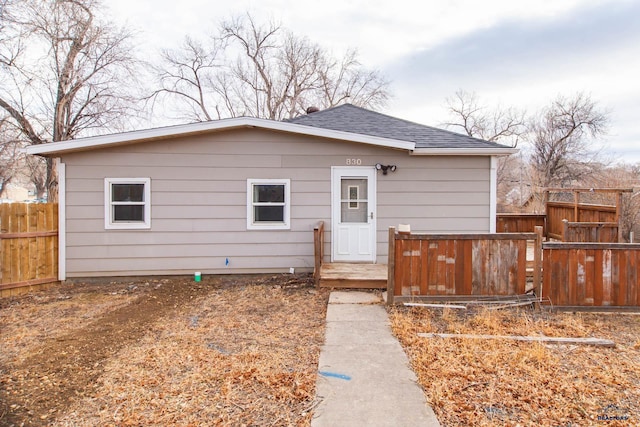 bungalow-style home with fence and roof with shingles