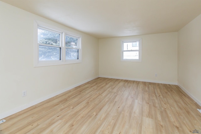 spare room with light wood-type flooring and baseboards