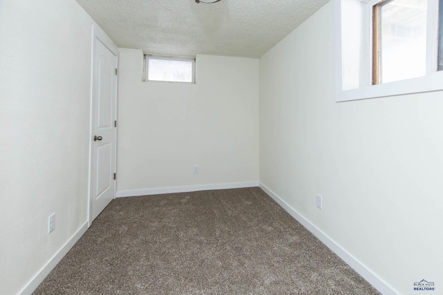 carpeted spare room with baseboards and a textured ceiling