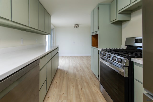 kitchen featuring light wood-style flooring, appliances with stainless steel finishes, light countertops, and baseboards