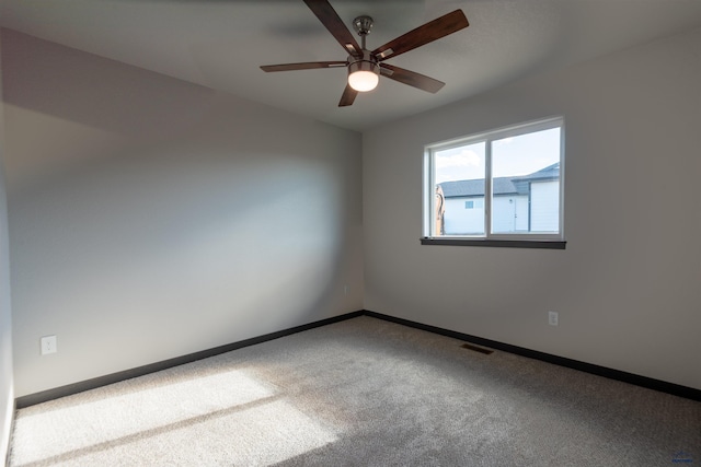 carpeted empty room with ceiling fan, visible vents, and baseboards