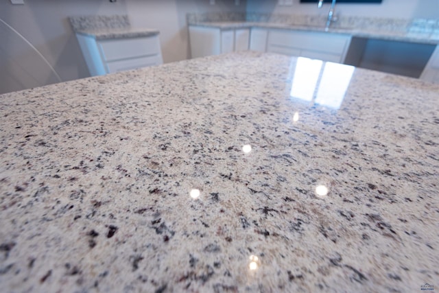 interior details with light stone countertops and white cabinetry