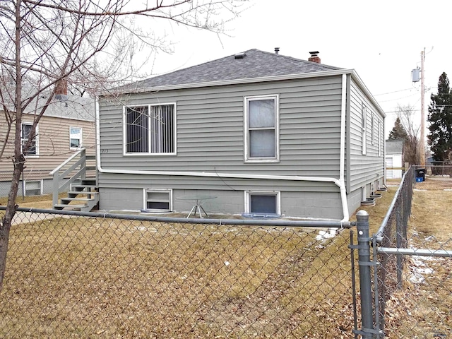 exterior space featuring a shingled roof, fence, and a chimney