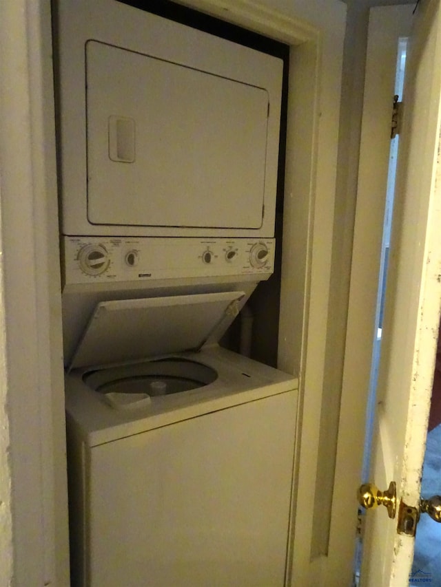 washroom featuring stacked washer and dryer and laundry area