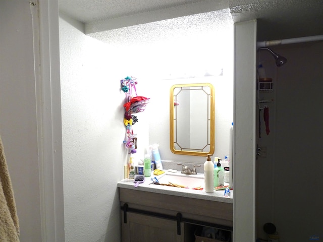 bathroom featuring a textured ceiling and vanity