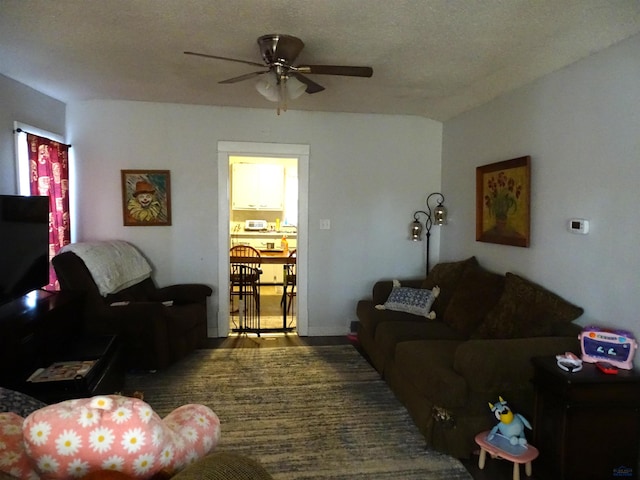 living area with a textured ceiling and a ceiling fan