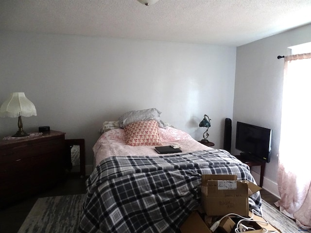 bedroom featuring a textured ceiling and wood finished floors