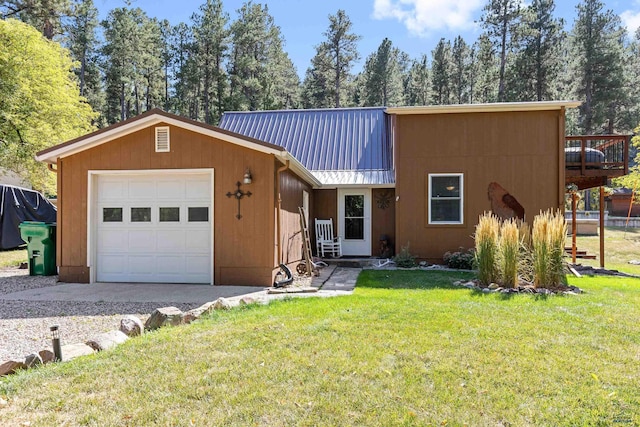 view of front of home featuring a garage, a front lawn, and metal roof