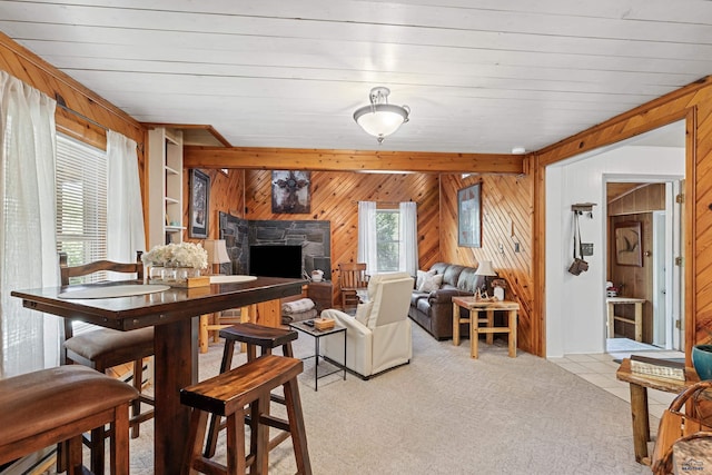 dining space with light carpet, wood walls, and a fireplace