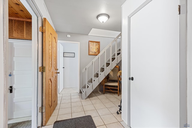 foyer entrance featuring light tile patterned floors and stairs