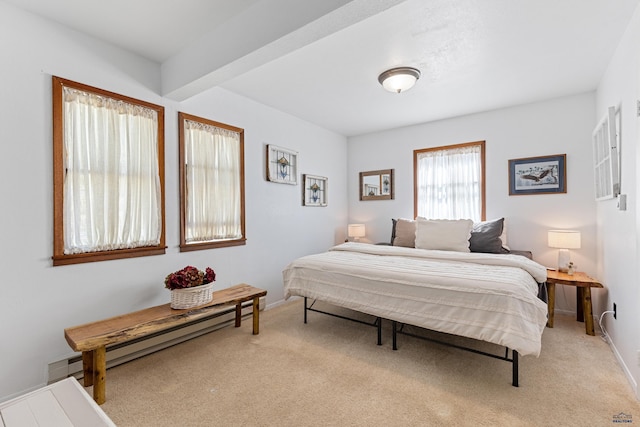 carpeted bedroom with a baseboard radiator and baseboards