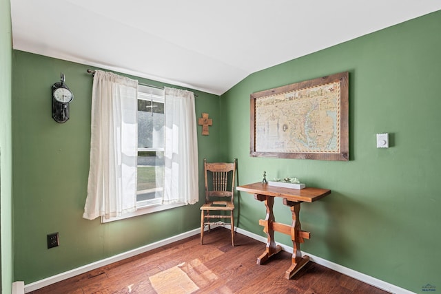 sitting room featuring baseboards, vaulted ceiling, and wood finished floors