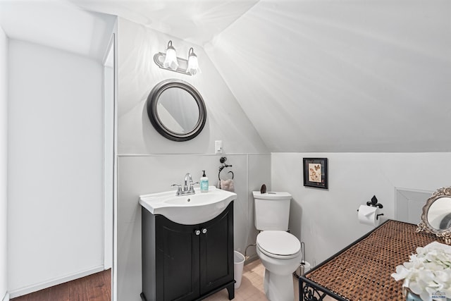 bathroom with vaulted ceiling, vanity, and toilet