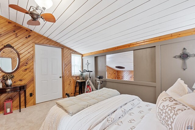 carpeted bedroom featuring lofted ceiling and wooden walls