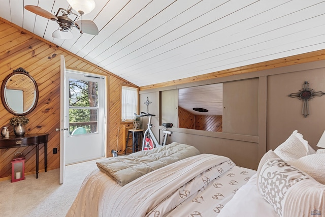 carpeted bedroom featuring vaulted ceiling and wood walls