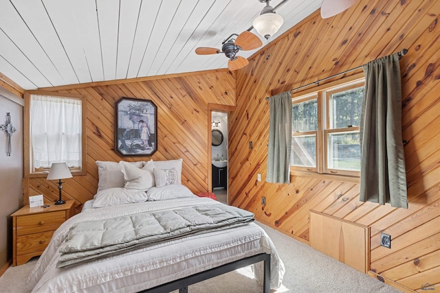 bedroom with ceiling fan, wooden ceiling, carpet floors, wood walls, and vaulted ceiling